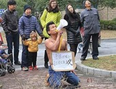 بالصور.. صينى يركع فى الشارع ليطلب العفو من زوجته بعد طرده من المنزل