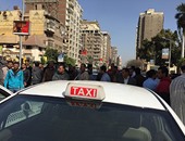 سائقو التاكسى الأبيض يحاولون ضرب ضابط مرور لتسجيله مخالفاتهم أثناء وقفتهم