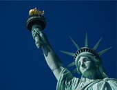 بالصور.. "تمثال الحرية" يتحدى ترامب ويرحب باللاجئين بلافتة "welcome"