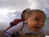 بالفيديو.. أمريكى يعلم طفله الرضيع ركوب الأمواج