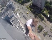 بالصور.. شاب روسى يتأرجح بين يدى صديقه فوق 40 طابقا من الأرض