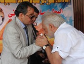 الفنان سامح الصريطى يُقبّل يد ساطع النعمانى خلال حفل اتحاد حماة الثورة
