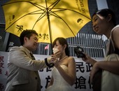 بالصور عروسان بهونج كونج يلتقطان صورا خلال ذكرى حركة "المظلة" الاحتجاجية