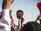 بالصور.. قناع لوجه "مرسى" يتصدر قائمة "التايم" لأفضل 10 صور بالعالم