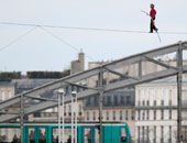 بالصور.. فرنسى يعبر نهر "السين" فوق حبل مشدود على ارتفاع 150 متراً