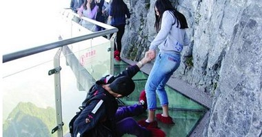 من قمة جبل.. صينية تجر صديقها فقد توازنه خوفا من المرتفعات