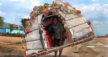 بالصور.. صينى يحمل منزله على كتفه ثلاثة أشهر