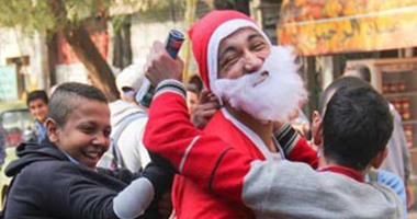 بالصور.. قارئ يرتدى زى بابا نويل ويوزع الهدايا على الأطفال