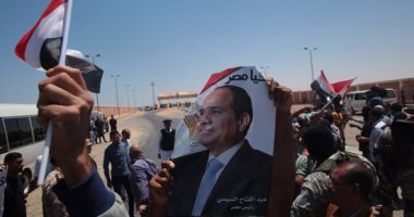 المصريون المحررون فى ليبيا يرفعون صور السيسى عقب وصولهم معبر السلوم