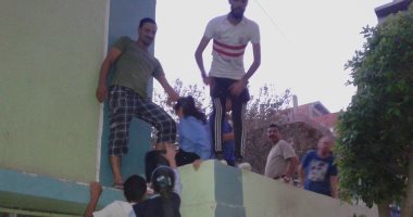 بالصور.. أولياء أمور يقفزون من أعلى سور مدرسة بفاقوس لحجز المقاعد