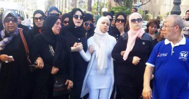 بالصور.. زوجة "شهيد بورسعيد" تودع جثمانه بالرداء الأبيض