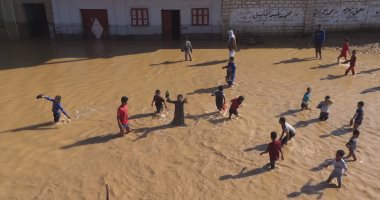 بالفيديو.. أطفال الحاجر بسوهاج يستخدمون أفلاق النخيل للسباحة بمياه السيول