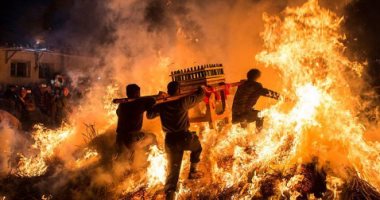 صينيون يحملون هيكلا لضريح ويقفزون فوق النار لجلب الحظ بالسنة الجديد