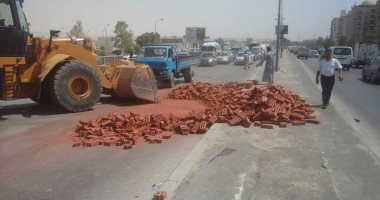 بالصور.. مرور القاهرة يستعين بلودر لرفع حمولة سيارة انقلبت بطريق الأتوستراد