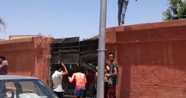 بالصور.. طلاب ثانوية بالأقصر يتسلقون سور المدرسة لطمأنة أولياء أمورهم