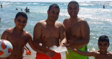 مصطافون يلتقطون الصورة التذكارية مع قنديل البحر