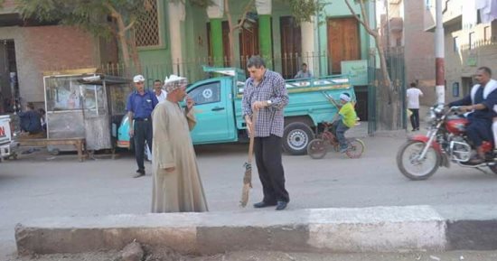 بالصور .. رئيس مدينة منفلوط يكنس الشوارع..ويشرح طريقة الكنس الصحيح