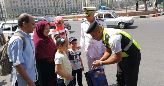 بالصور.. رجال الشرطة يوزعون أدوات مدرسية وإرشادات المرور على الطلبة