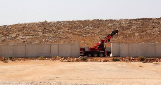 بالصور.. جرافات "أردوغان" العسكرية تهدم الجدار العازل بين سوريا وتركيا