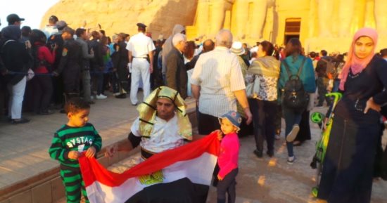 مصرى يروج للسياحة بـ"زى فرعونى وعلم مصر" فى مهرجان تعامد الشمس بأبوسمبل
