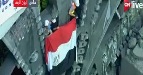 العاملون بأنفاق قناة السويس يرفعون علم مصر على ماكينة الحفر العملاقة