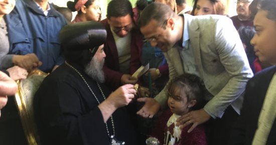 صور.. أسقف أسيوط يوزع الحلوى والشيكولاته على الزائرين للكاتدرائية