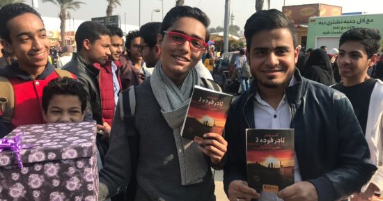 صور.. جمهور أحمد يونس يحتفل بعيد ميلاده وتوقيع روايته بمعرض الكتاب