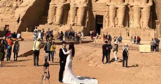 عروسان من الصين يحتفلان بزفافهما أمام ساحة معبد رمسيس الثانى بأبوسمبل  
