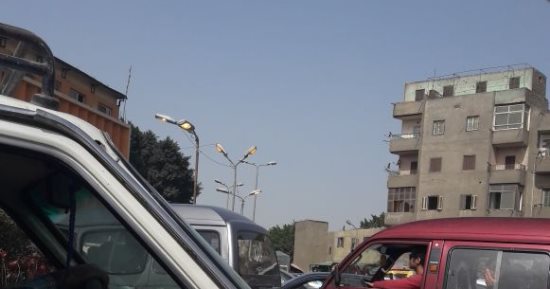 قارئ يرصد أعمدة إنارة مضاءة نهارا أمام قسم إمبابة بكورنيش النيل