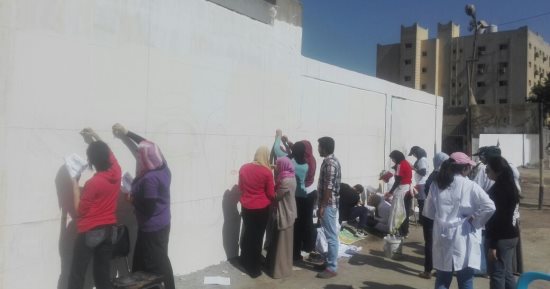 صور.. طلاب فنون تطبيقية بجامعة حلوان يحولون أسوار شارع السودان للوحة فنية