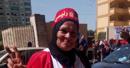 "انتو فى الميدان وإحنا فى اللجان".. رسالة سيدة تطوف شوارع الزقازيق بعلم مصر