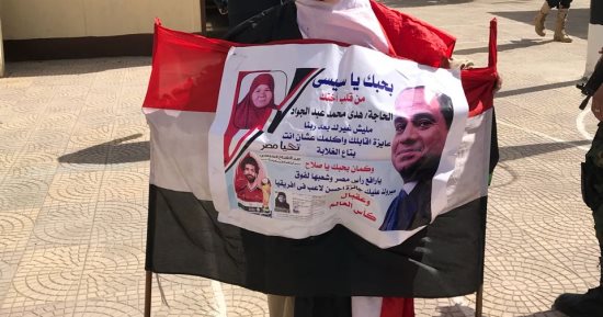السيسى ومحمد صلاح فى لافتة واحدة بيد سيدة تدلى بصوتها بمصر الجديدة