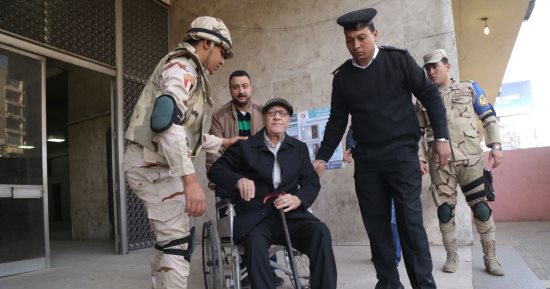 مجندو الجيش والشرطة يحملون قعيد للإدلاء بصوته الانتخابى فى مدينة نصر (صور)