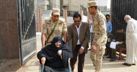 صور.. رئيس لجنة يساعد مسنة فى الإدلاء بصوتها بانتخابات الرئاسة بسوهاج