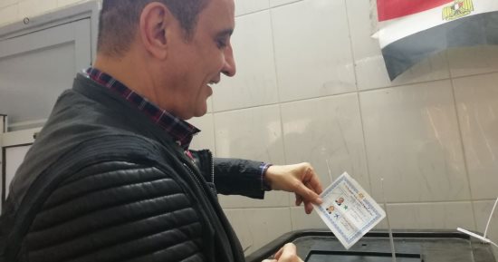 صور.. طارق علام يدلى بصوته ويوزع حلوى على الناخبين وقوات الأمن بالدقى