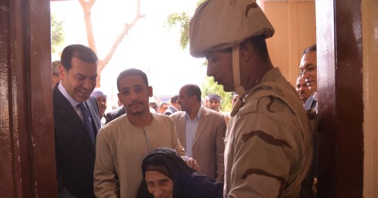 صور .. محافظ أسيوط يساعد سيدة مسنة لدخول اللجنة الانتخابية للادلاء بصوتها