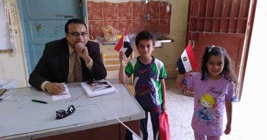صور.. رئيس لجنة ببنى سويف يهدى أعلام مصر للناخبين وأطفالهم 