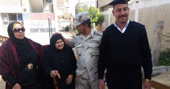 قوات تأمين اللجان بالشرقية تساعد مسنة للإدلاء بصوتها فى الانتخابات