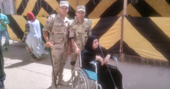 صور.. رجال الجيش يساعدون عجوز للإدلاء بصوتها فى حدائق حلوان