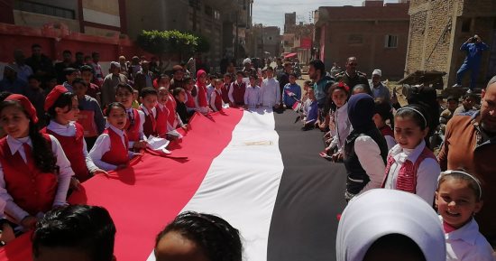 صور.. طلاب مدرسة بدمياط ينظمون مسيرة لاستقبال الناخبين بأعلام مصر