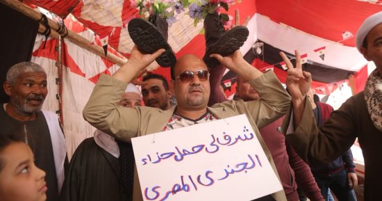 مصر تحفظ جميل جنودها.. ناخب بمدينة نصر يحمل بيادة الجيش فوق رأسه (صور)