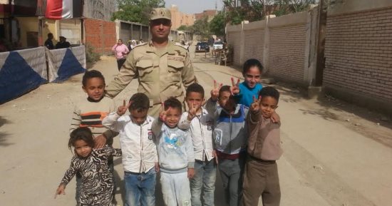 أطفال حدائق حلوان يلتقطون الصور التذكارية مع رجال الجيش أمام اللجان
