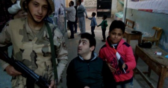 صور.. شاب على كرسى متحرك يدلى بصوته بزفتى: "تحيا مصر.. تحيا السيسى"