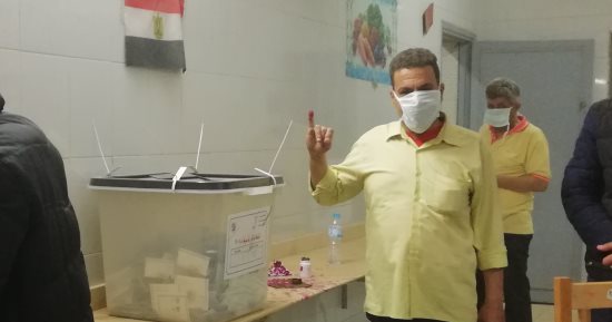 صور.. المصريون يتحدون الطقس السىء بالكمامات للمشاركة بالانتخابات فى الدقى