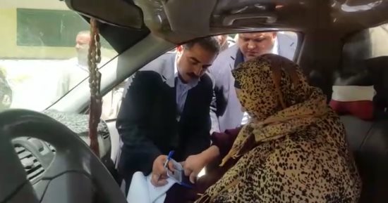 رئيس لجنة الشهيد يوسف بالشرقية يحمل استمارة تصويت لسيدة مسنة خارج اللجنة