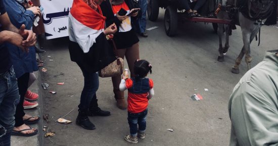 صور.. سيدة تصطحب أبنائها للتصويت فى الانتخابات مرتدين علم مصر 