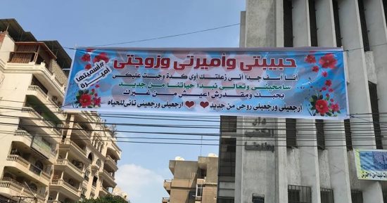 زوج يطلب السماح من زوجته بتعليق لافتة اعتذار لها أمام دار الكتب بطنطا