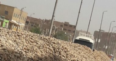 أكوام الزلط تعيق حركة السيارات بطريق السماد بأسوان