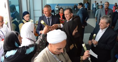 صور.. "جنينة" و "عادل" يستقبلان حجاج بيت الله الحرام العائدين بالورود
