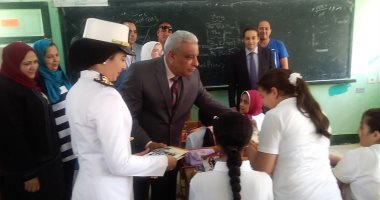 مدير أمن كفر الشيخ يوزع كراسات على الطلاب.. وطالبات يقبلن ضابطة شرطة